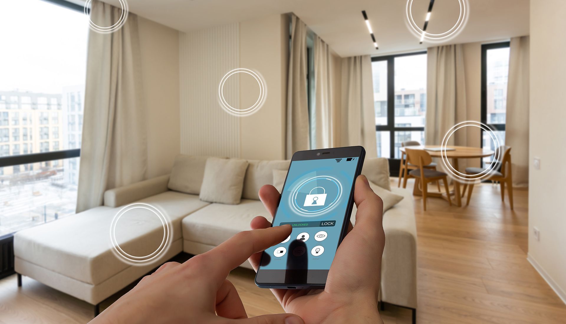 Person using a smartphone to control a smart home; living room background with sofa and windows.