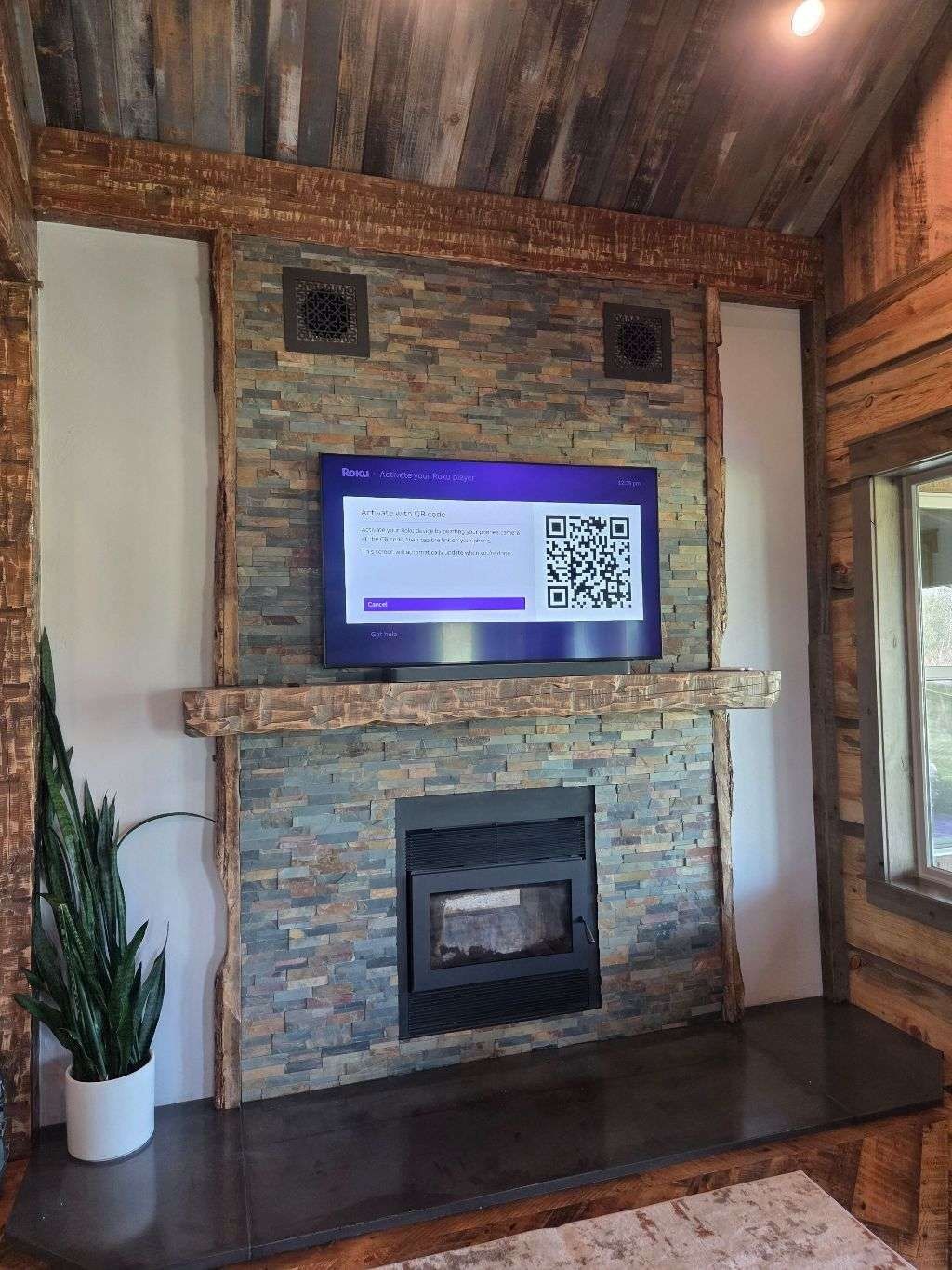 Flat screen TV and in-ceiling speakers on stone fireplace wall — Smart Home Solutions Montana