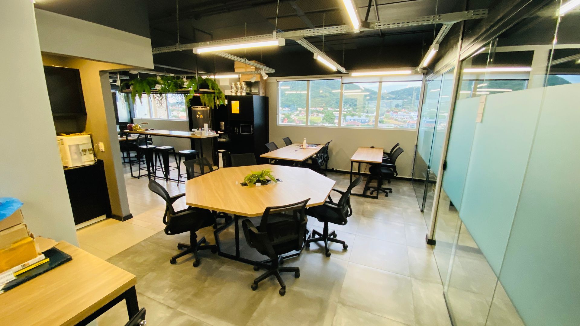 Uma sala grande com mesas e cadeiras no Sandbox Coworking