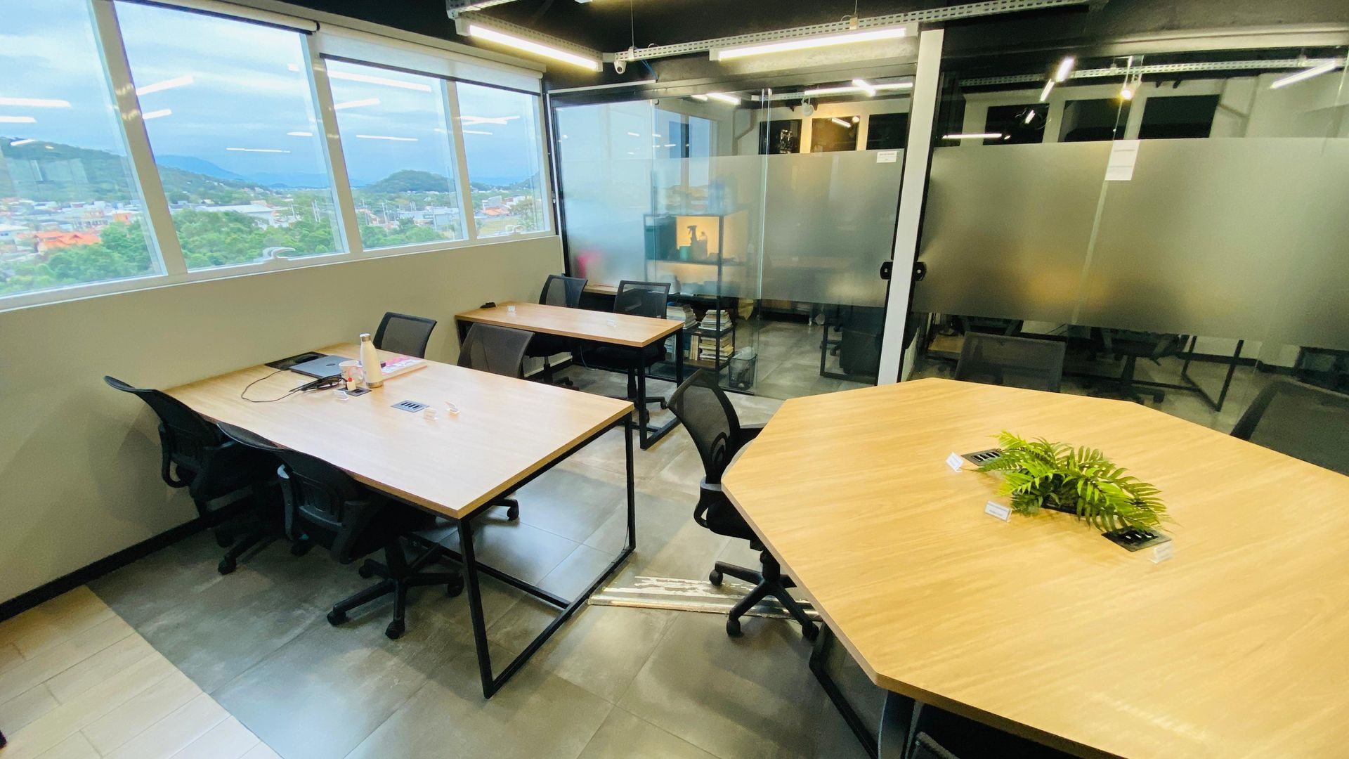 Há muitas mesas e cadeiras na sala.