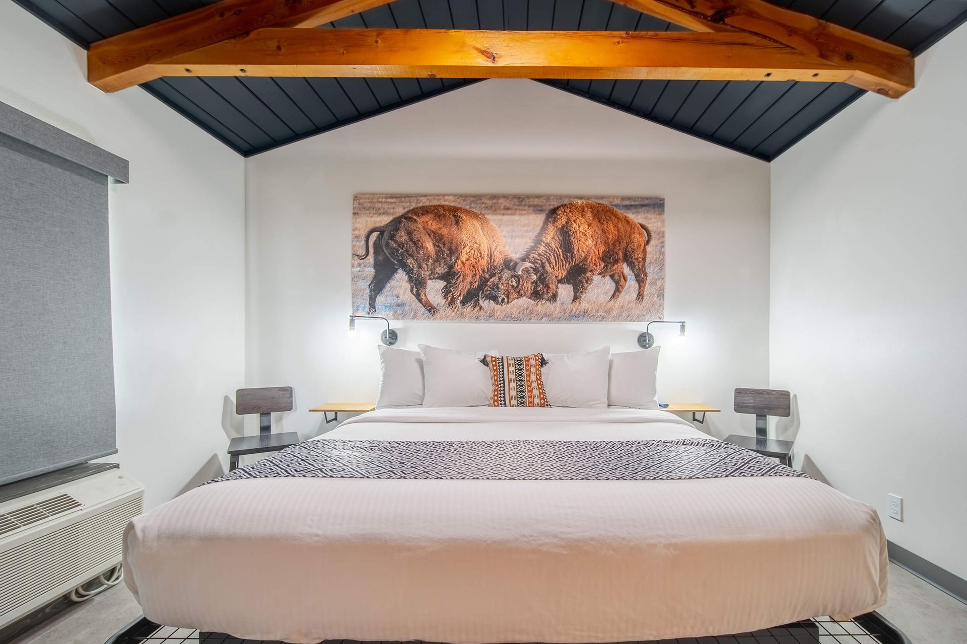 A wooden fireplace with a bull skull on the wall above it.