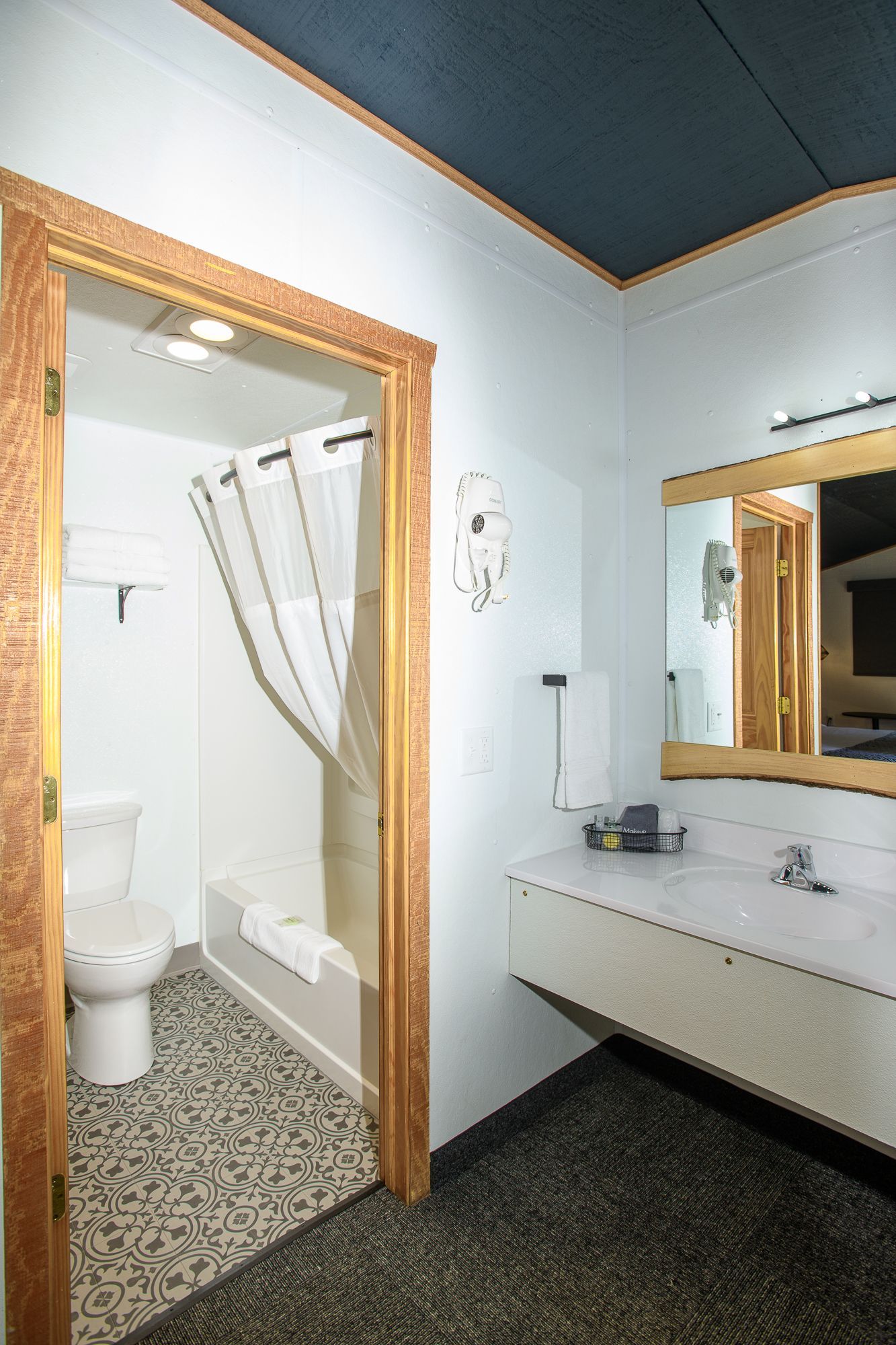 A bathroom with a toilet , sink , and mirror.