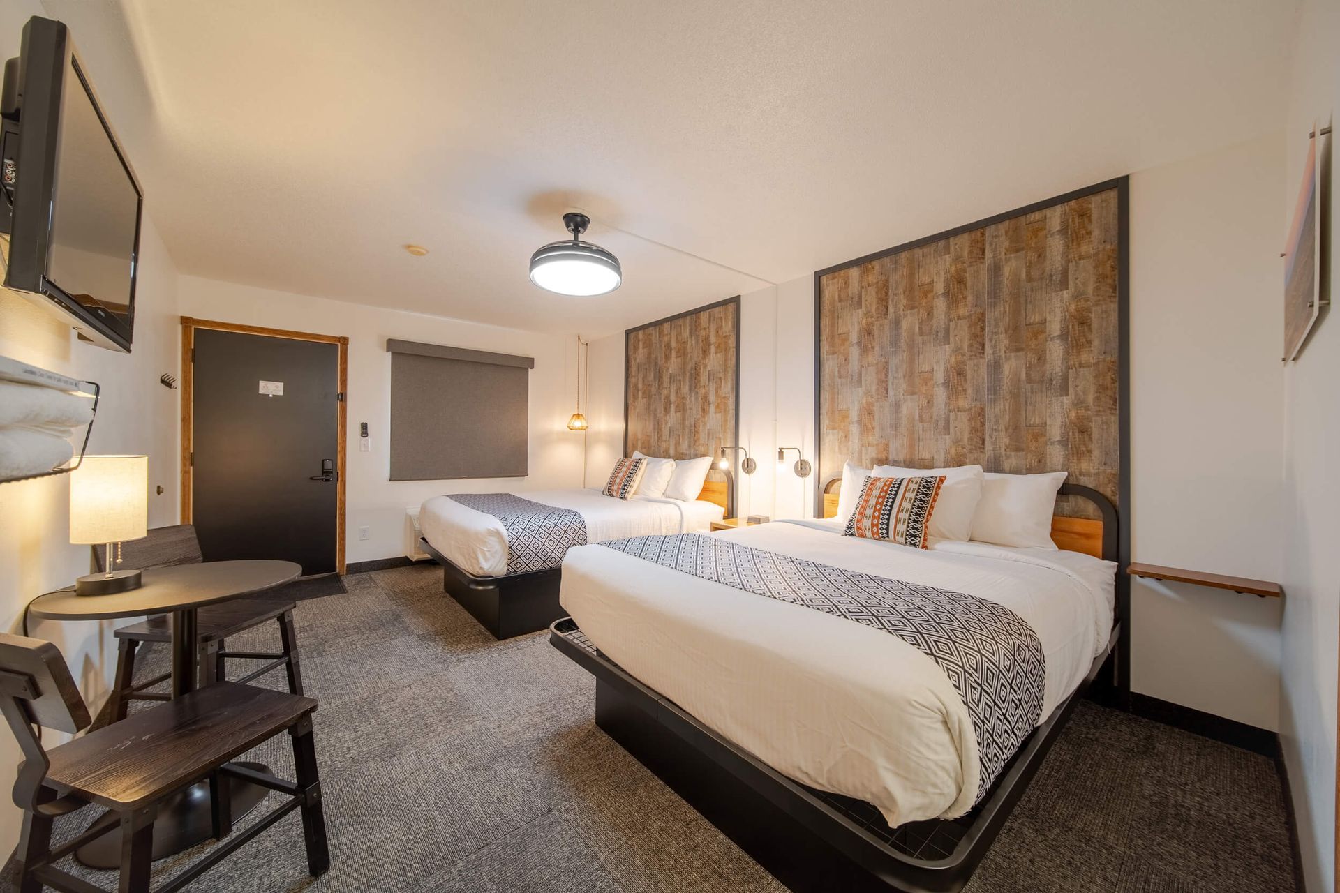 A hotel room with two beds and a picture on the wall.