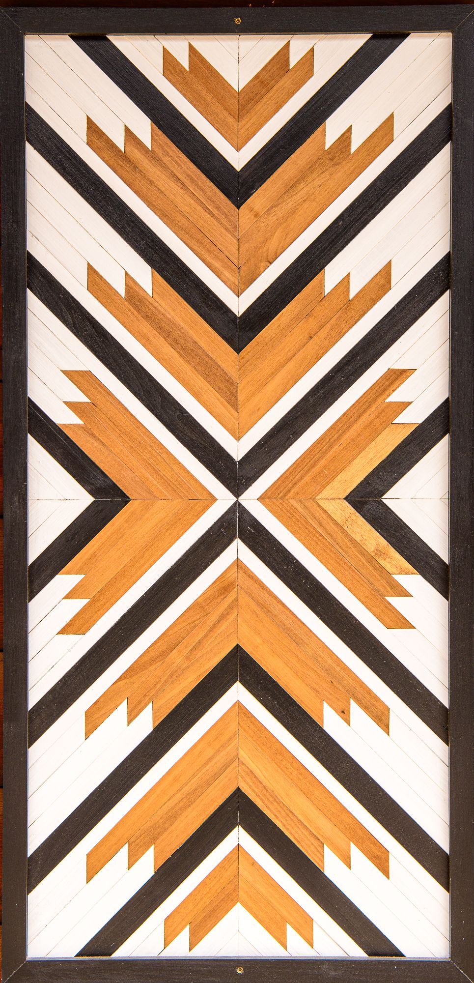 A wooden sculpture with a black and white pattern on it.