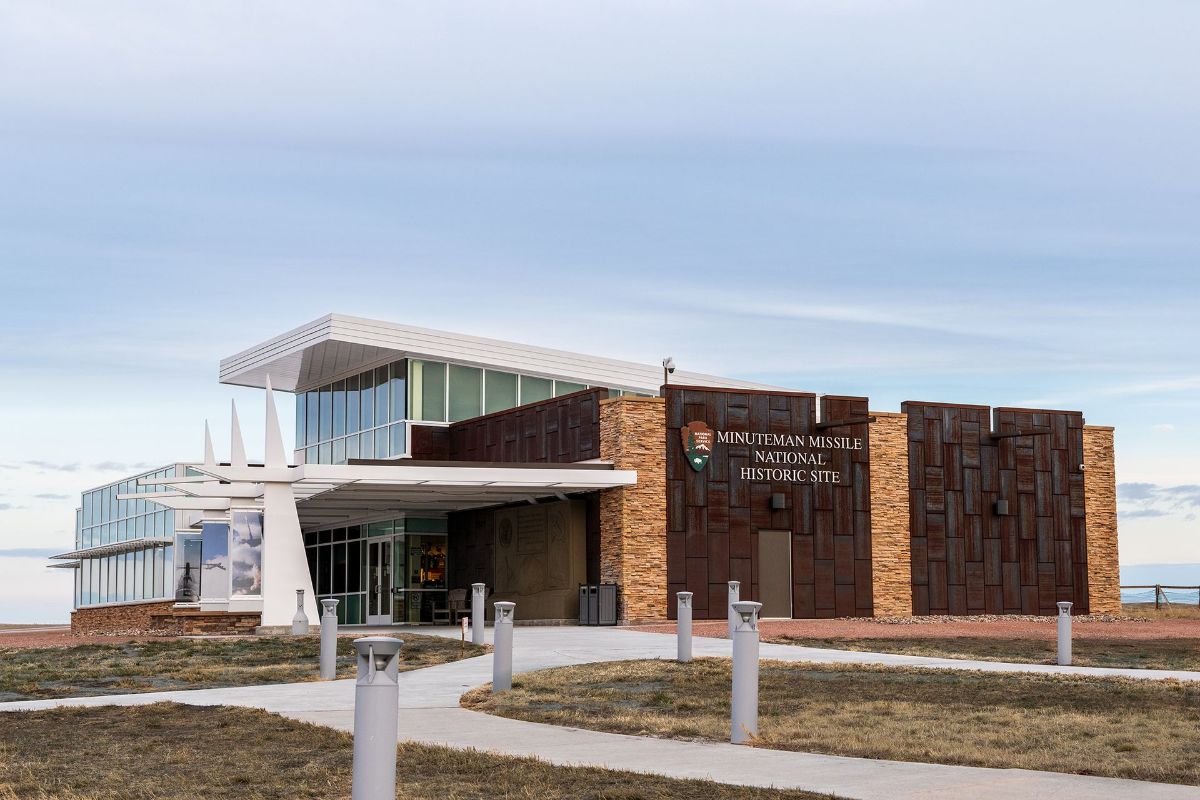 A large building with a lot of windows is sitting on top of a hill.