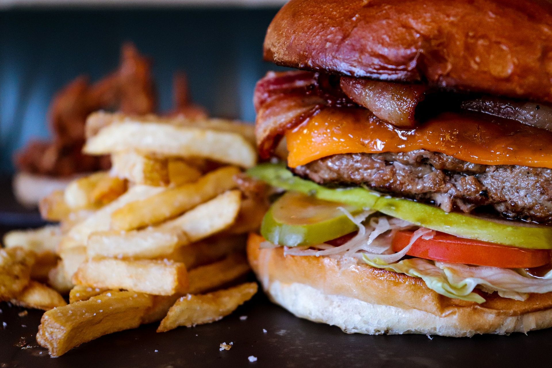 A close up of a hamburger and french fries on a table.