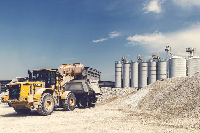 A bulldozer is loading a dump truck at a construction site.