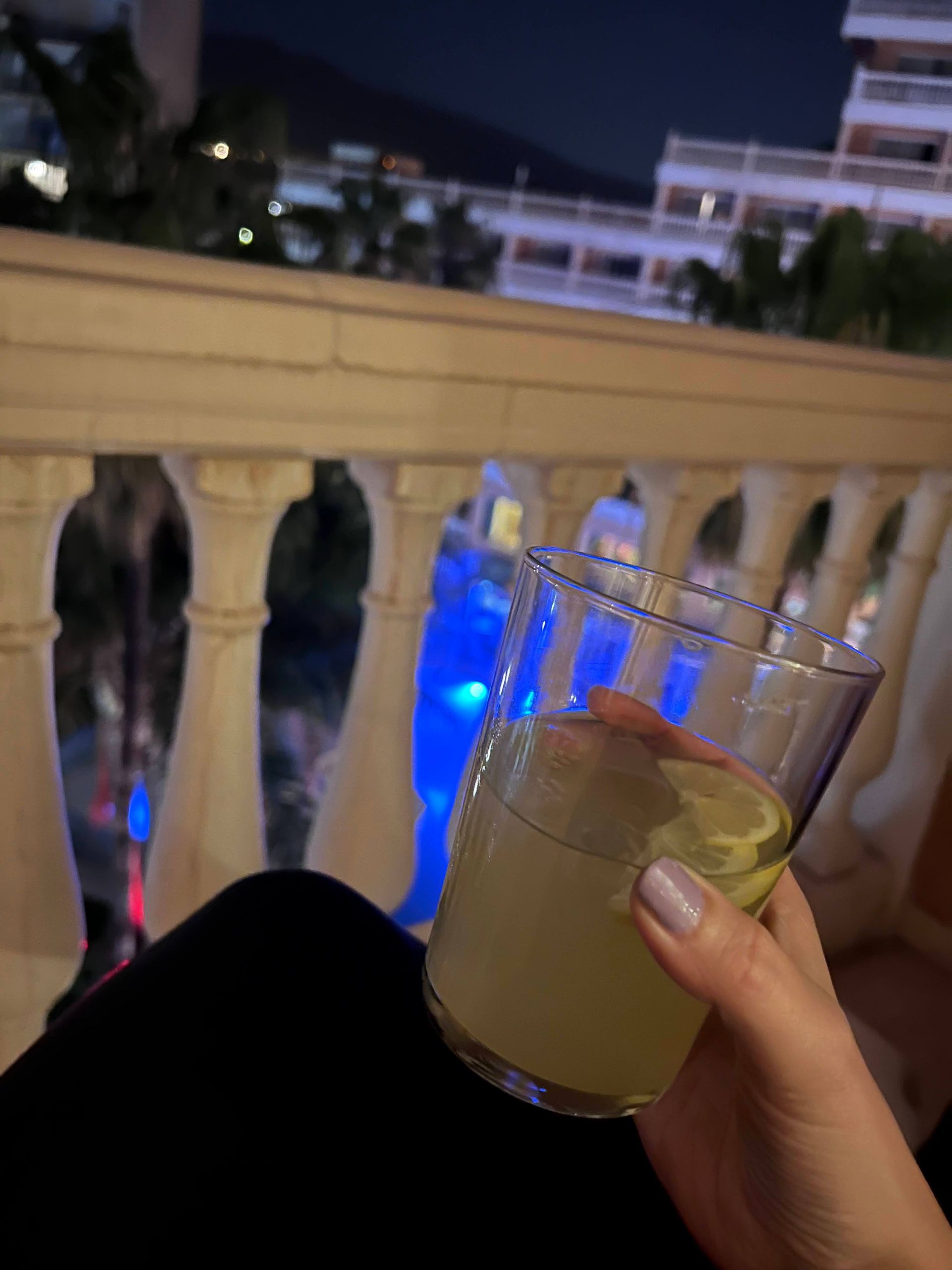 Sitting on a balcony with a drink in hand