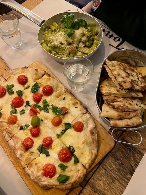 Close-up of dinner with pizza, pasta and foccacia