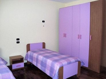 camera viola con due letti singoli e armadio