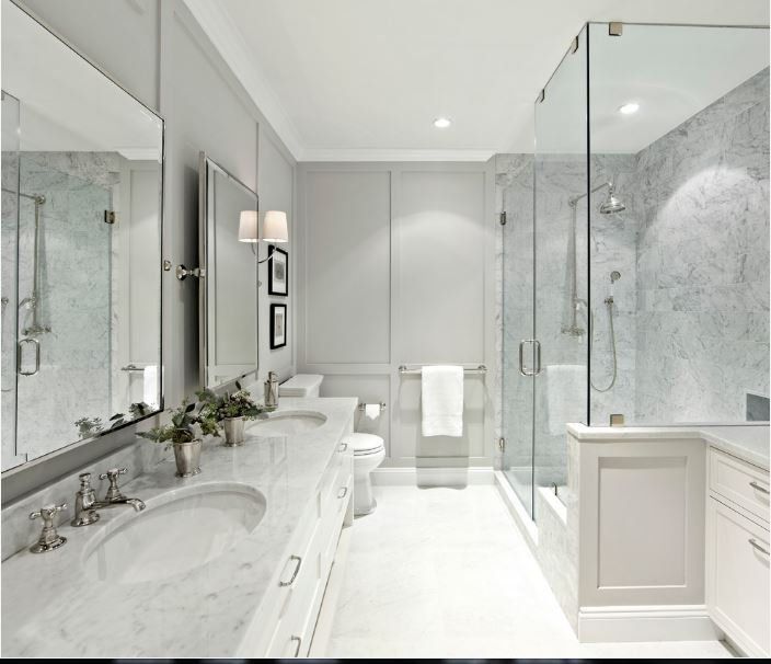 A bathroom with two sinks a toilet and a walk in shower