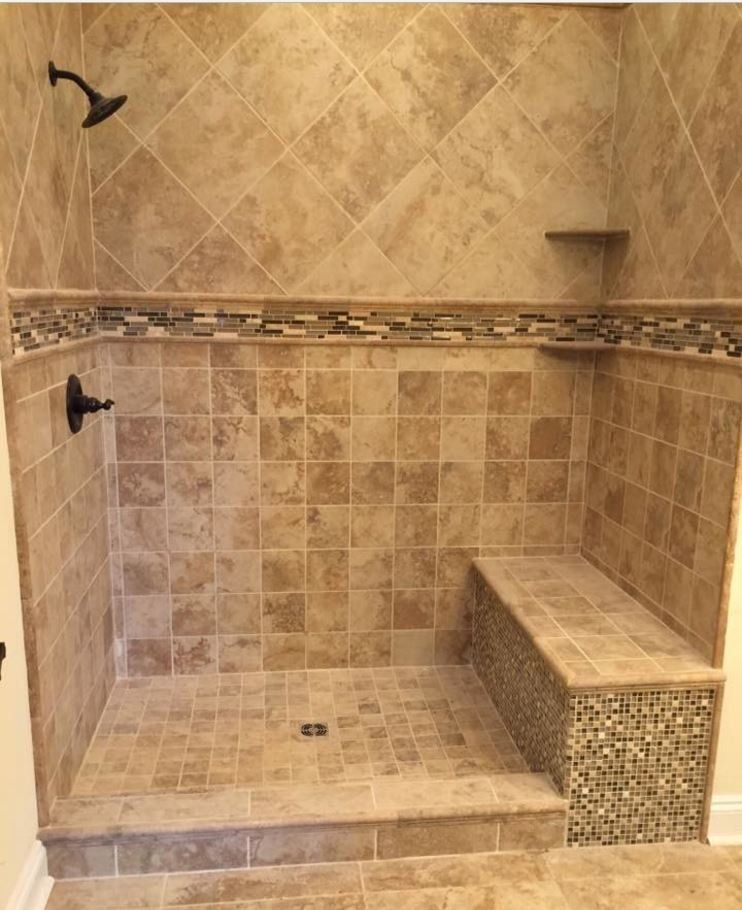 A walk in shower with a bench and a shower head