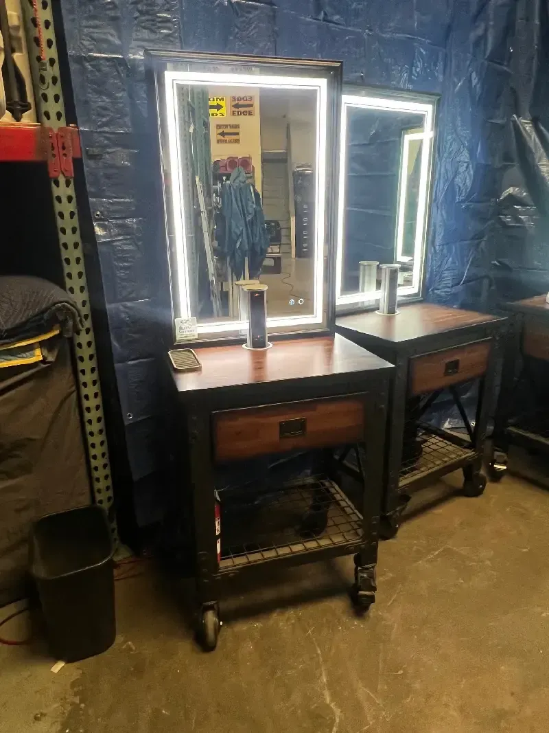 Two nightstands with mirrors, in front of a blue tarp.