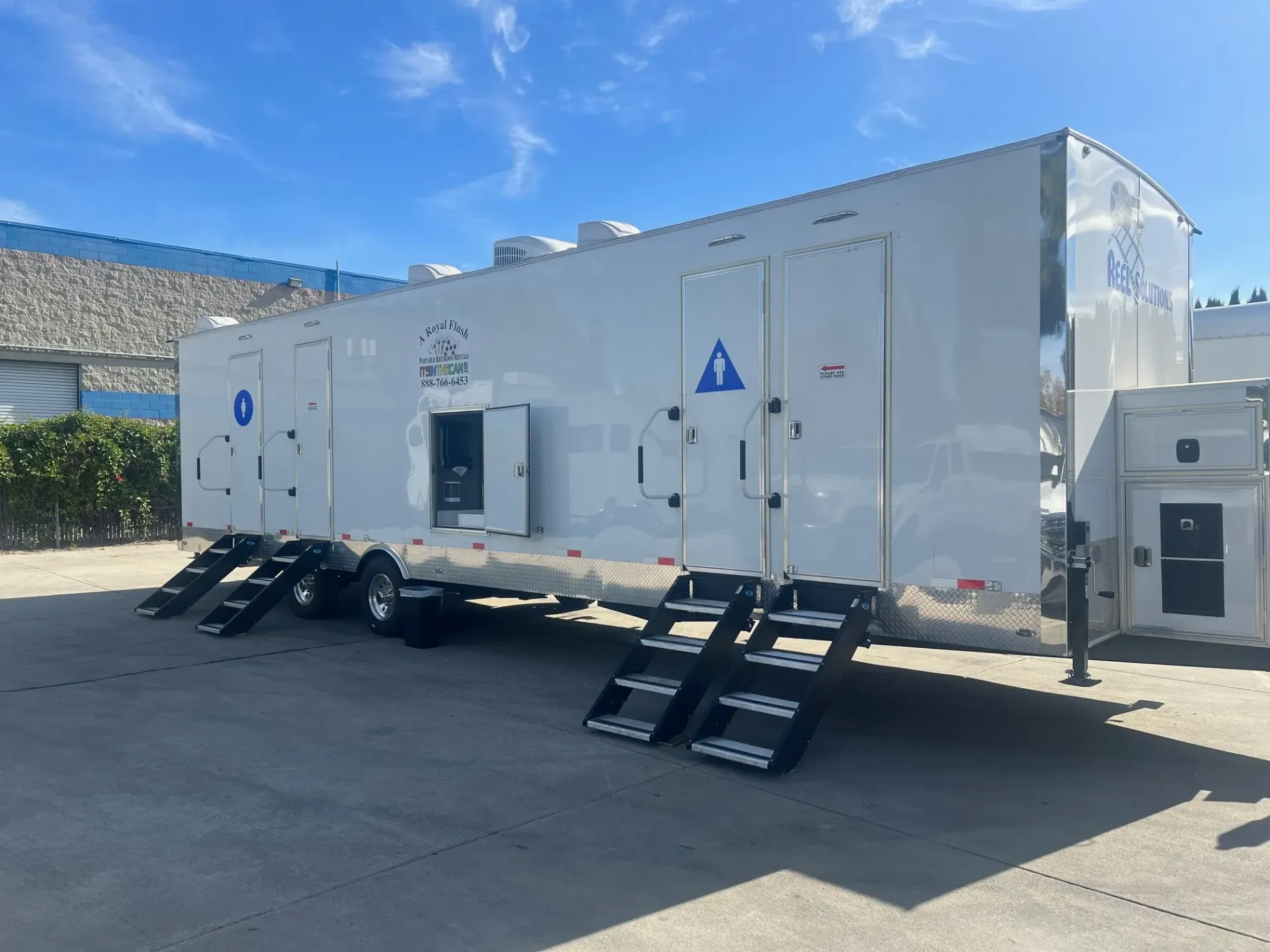 White mobile restroom trailer with steps deployed.
