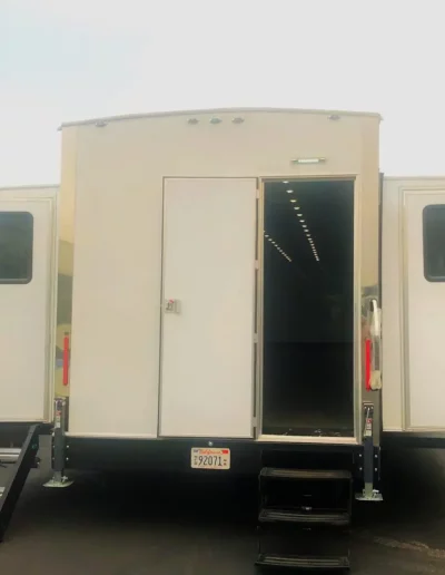 White trailer with an open door and steps. License plate visible.