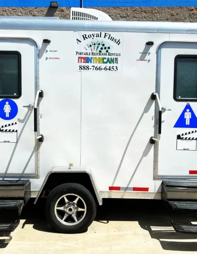 White portable restroom trailer labeled 