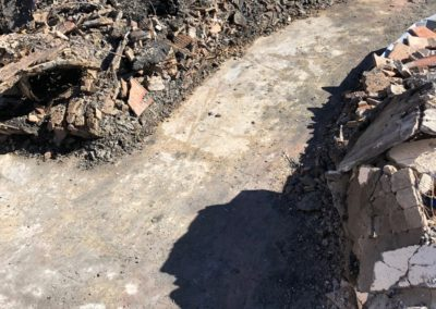 Debris and a curved concrete path, possibly after a fire.