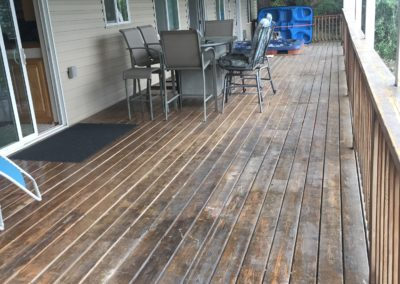 Wooden deck with outdoor dining set and sliding glass door.