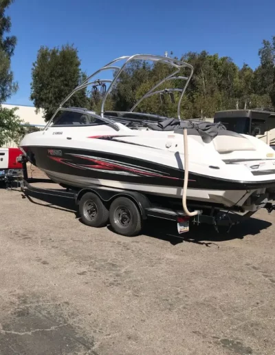 White and black speedboat on a trailer, under a blue sky.