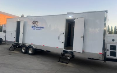 White trailer with two open doors, steps, and logo: