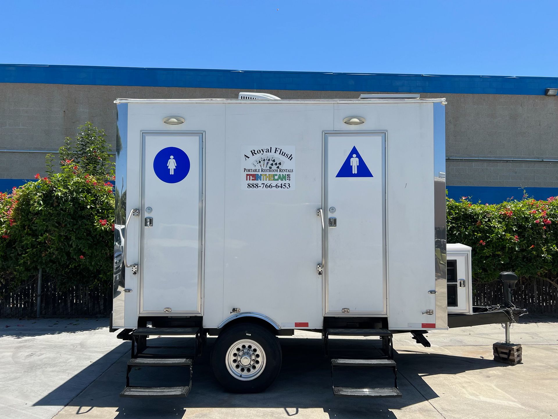 White portable restroom trailer with two separate entrances.