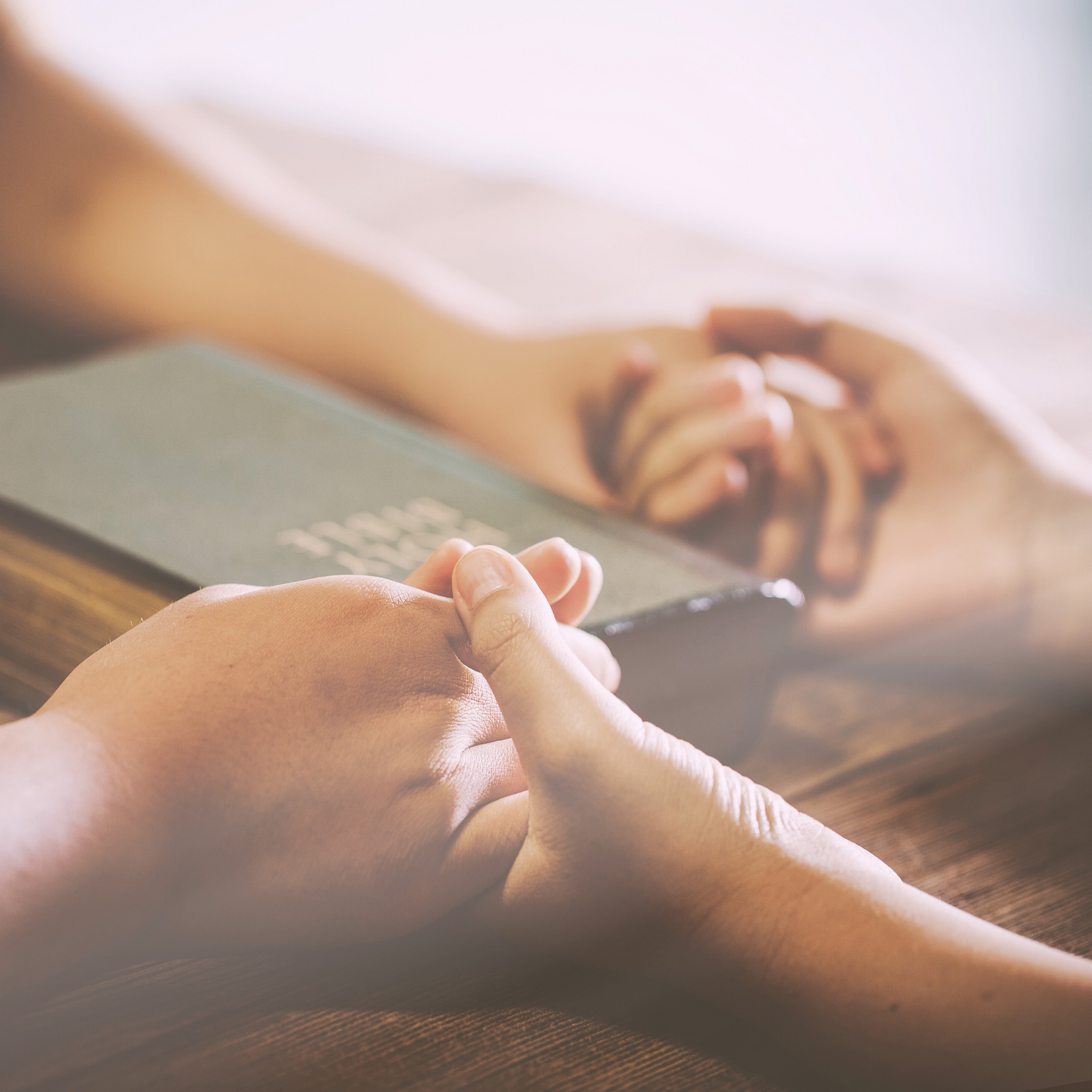 Hands in Prayer over Bible