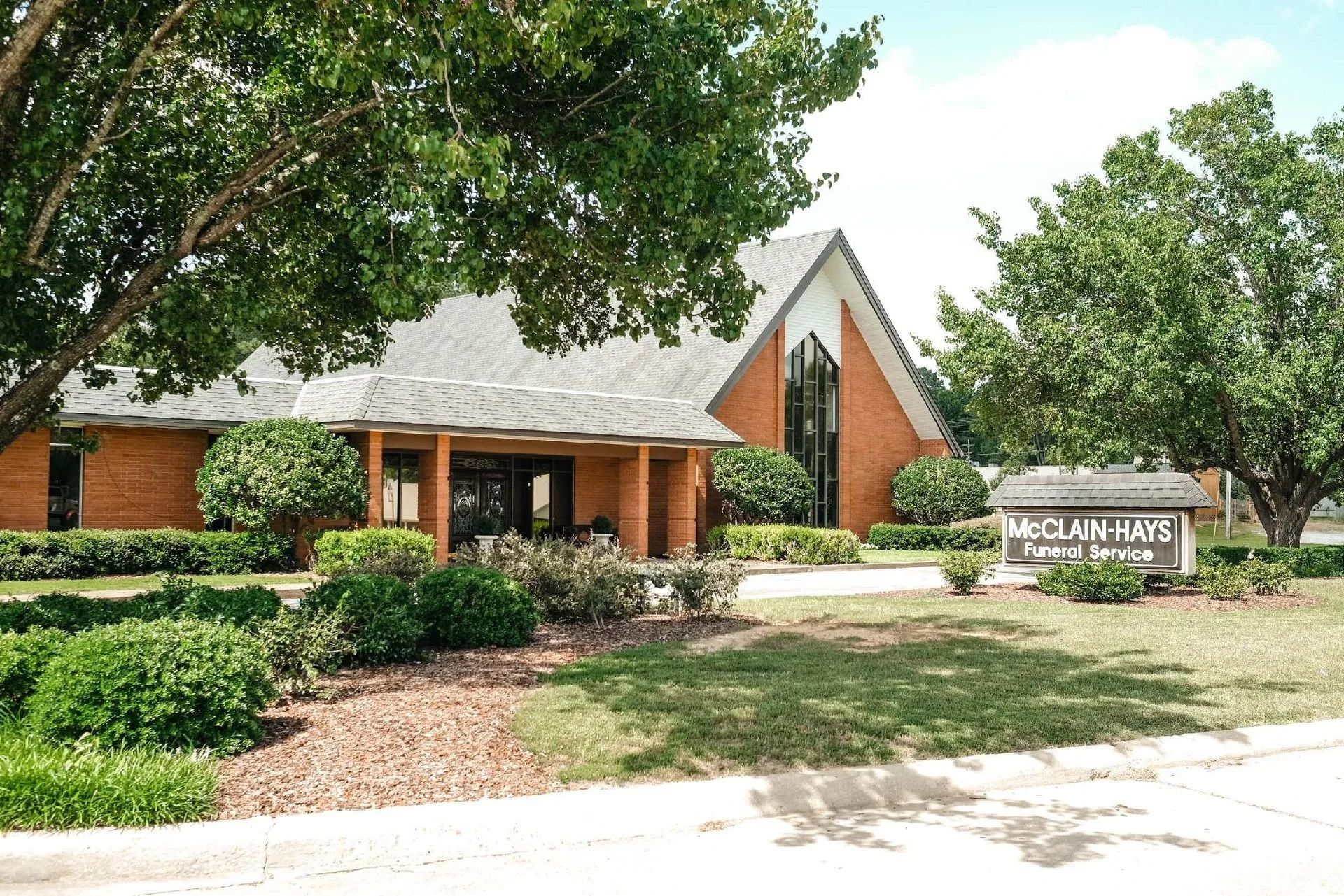 Brick building with arched window, sign reads
