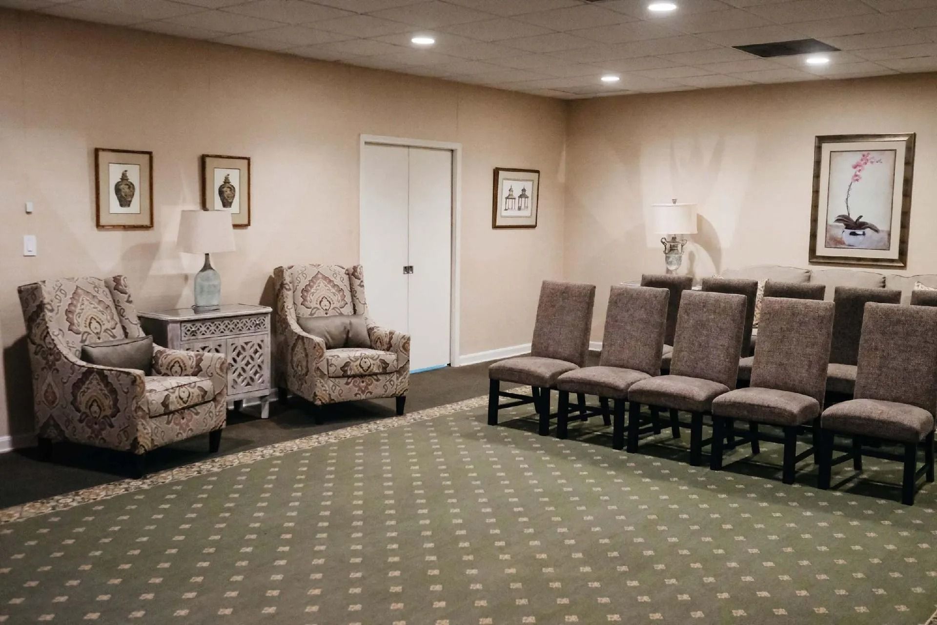 Interior of a room with chairs and artwork, likely a waiting area.