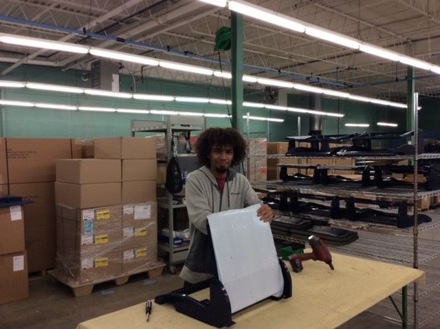 A man is holding a piece of paper in a warehouse