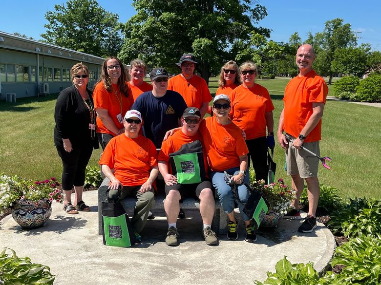 A group of people wearing orange shirts are posing for a picture.