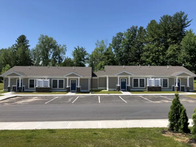 A row of houses with a parking lot in front of them