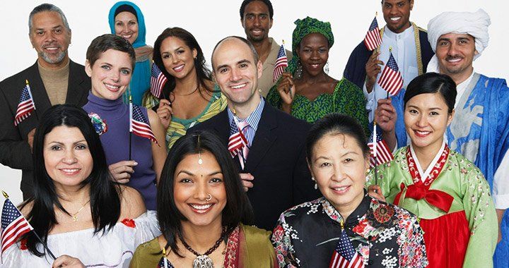 group of people with varying ethnicities holding american flags