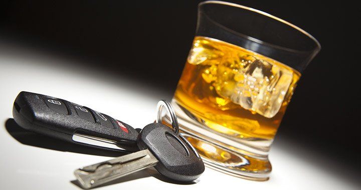car keys in front of glass of liquor