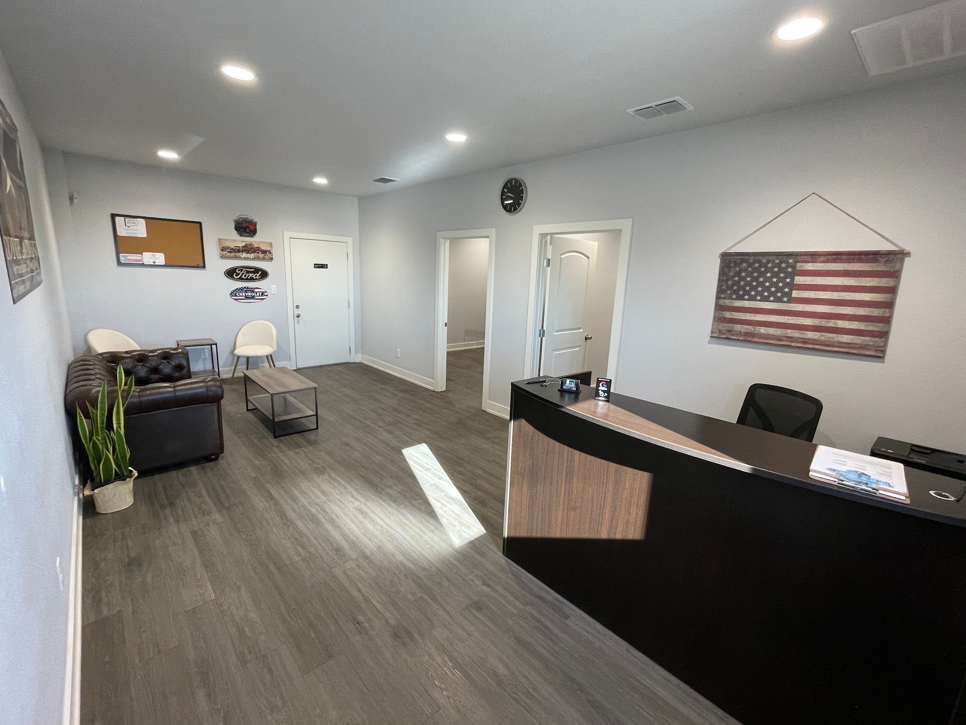 Office waiting area with a reception desk, chairs, and an American flag | Coyote Automotive