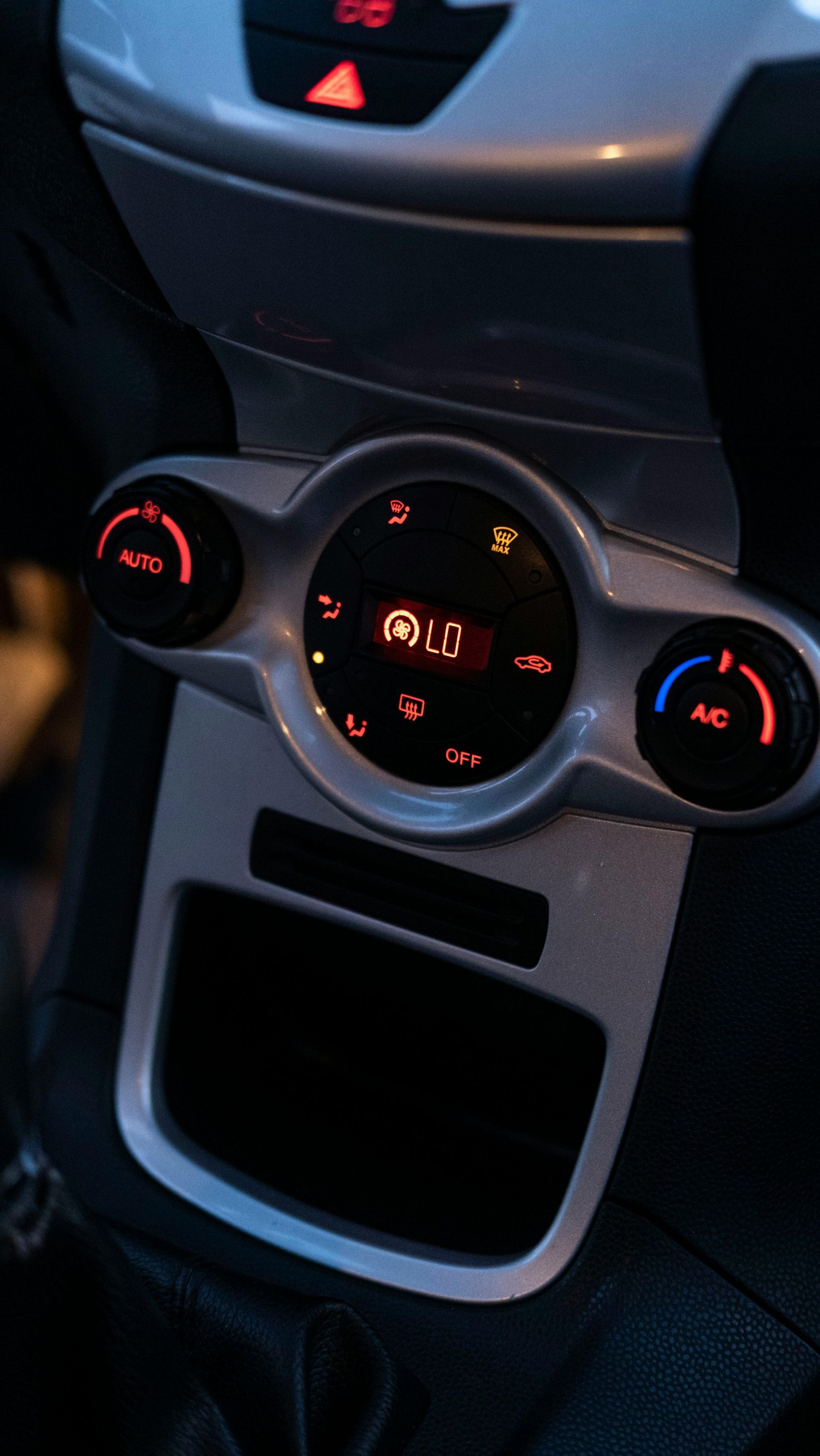 Car dashboard with illuminated controls. Silver panel with air conditioning and display | Coyote Au