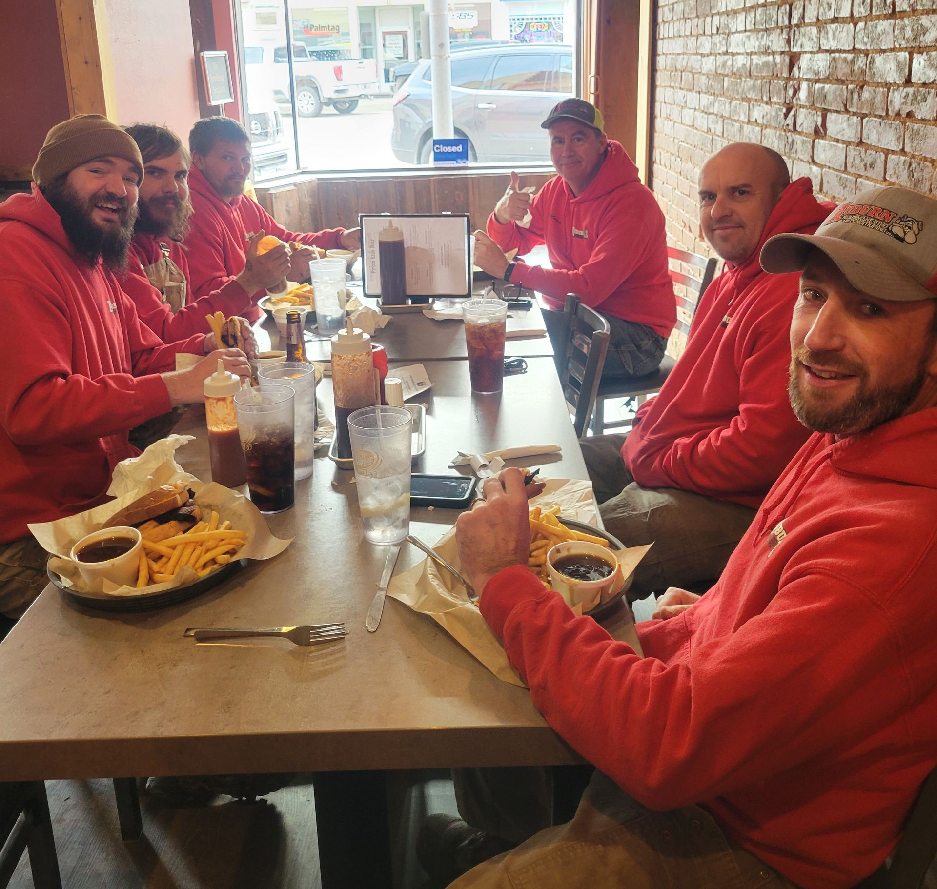 A Group of Men Are Sitting at A Table Eating Food