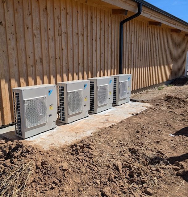 A Row of Air Conditioners Are Lined up In Front of A Wooden Building