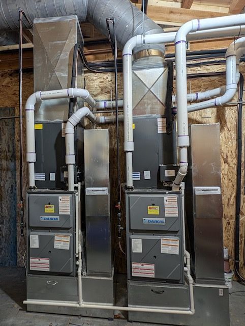 Two Air Conditioners Are Sitting Next to Each Other in A Basement.