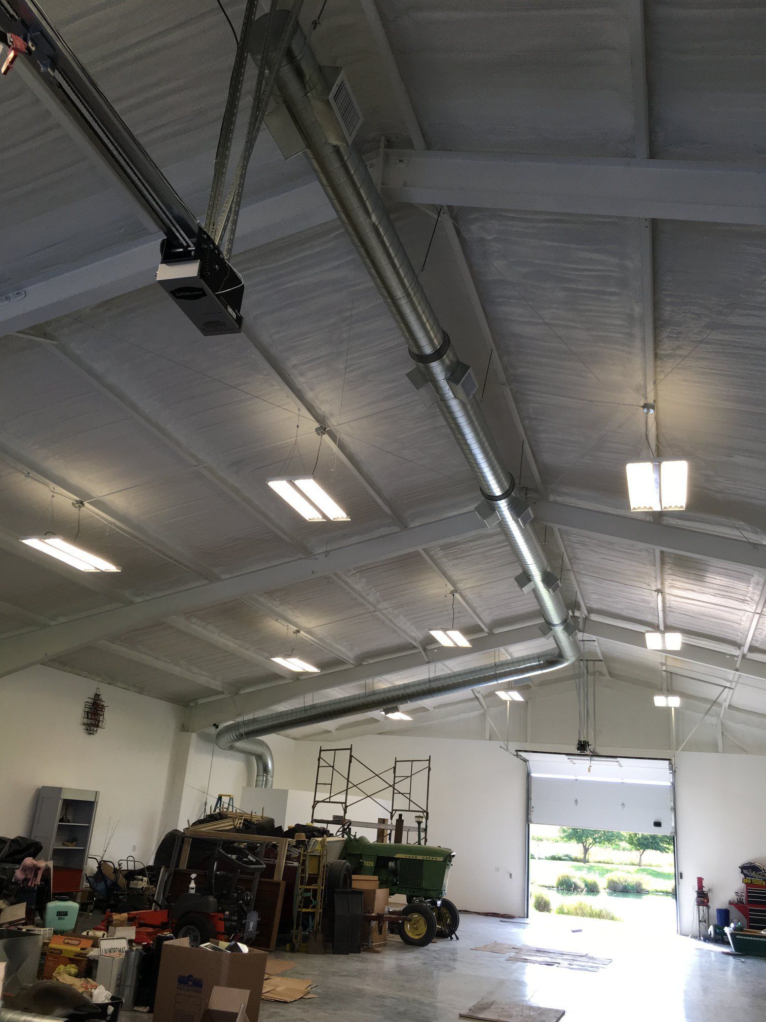 A large garage with a tractor parked inside of it.