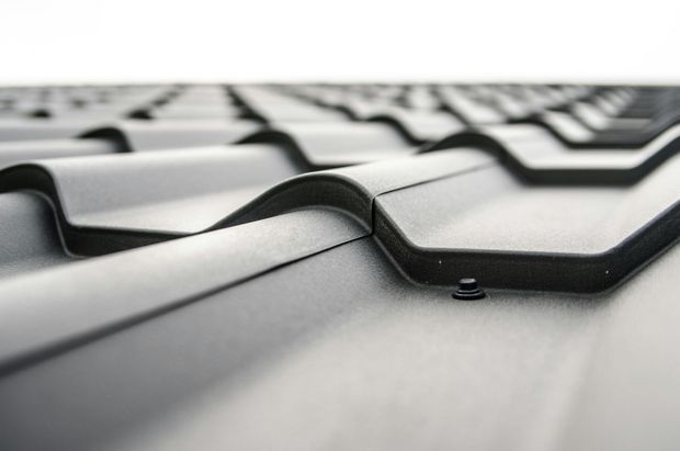 Close-up view of a dark gray metal roof with interlocking panels.