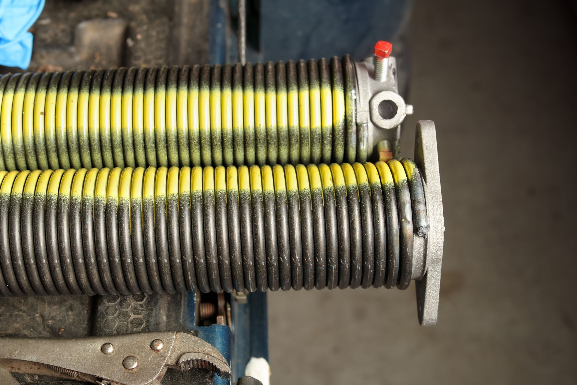 Woman in straw hat smiles, holding wine glass near a lake.