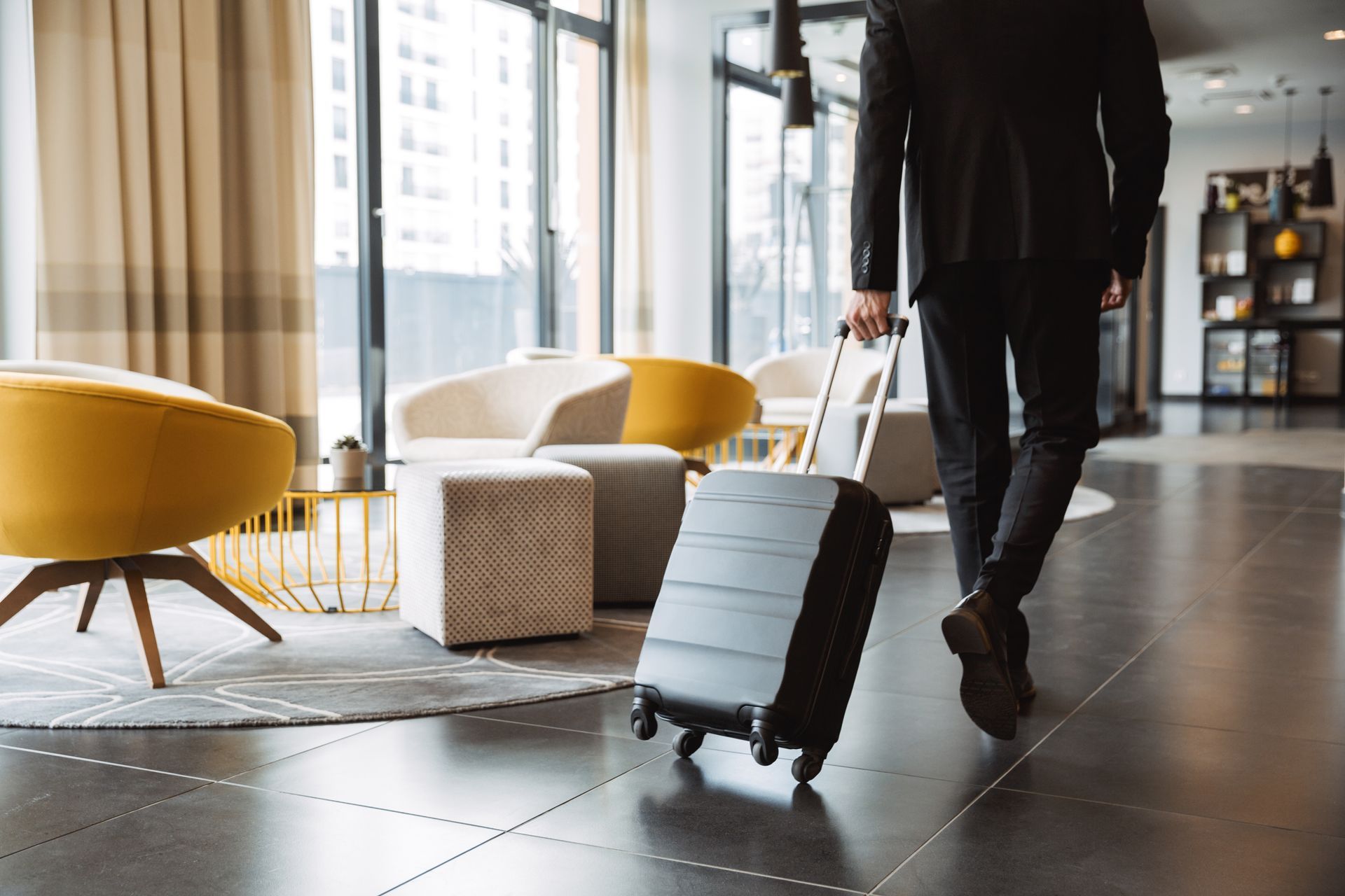 person rolling a suitcase in a hotel lobby