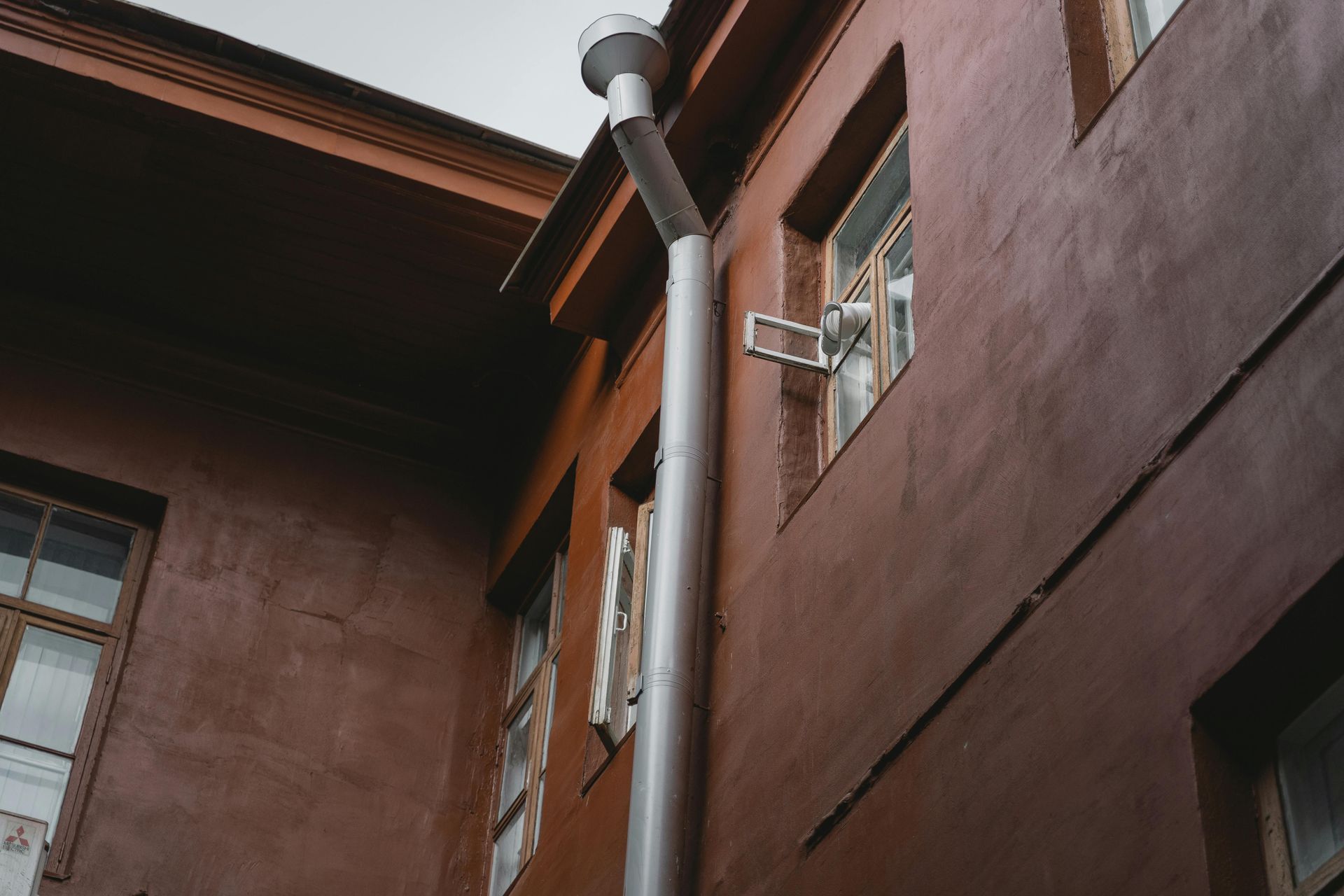 A drainpipe is hanging from the side of a building.