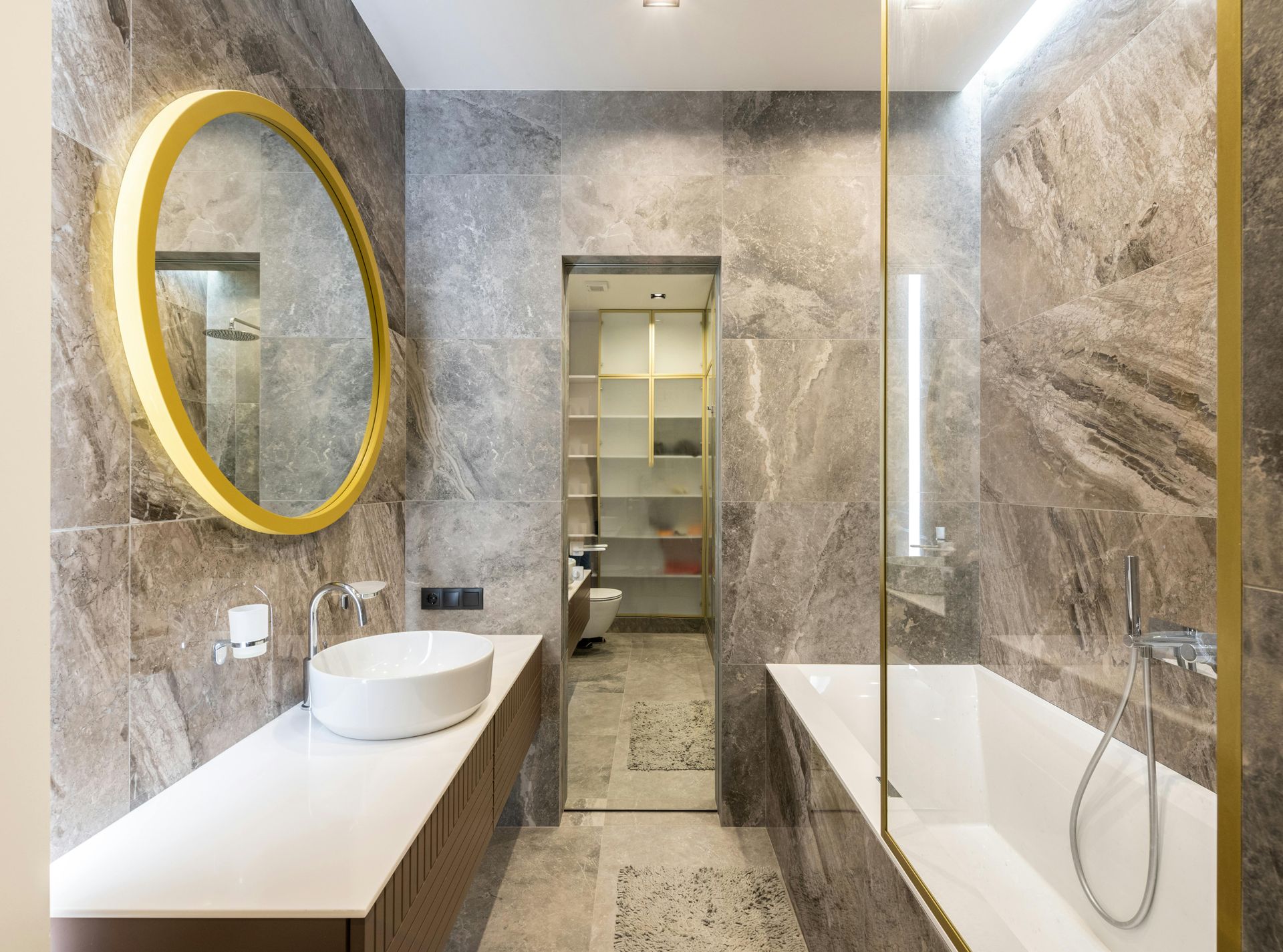 A bathroom with a sink , tub , mirror and walk in closet.