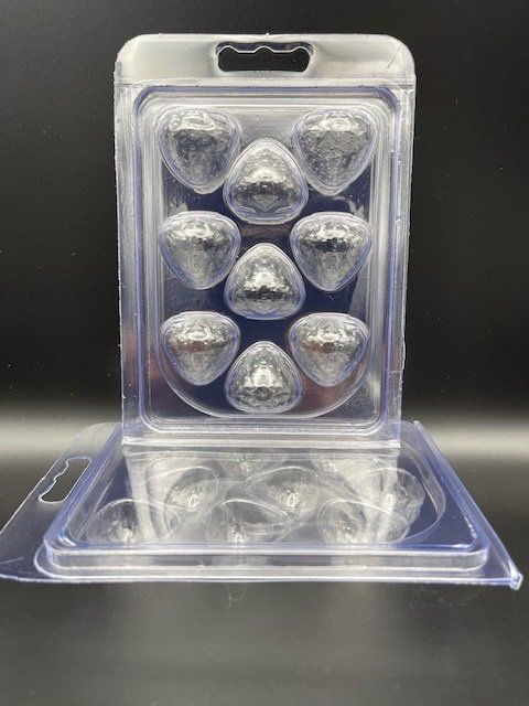 A clear plastic container filled with hearts on a table.