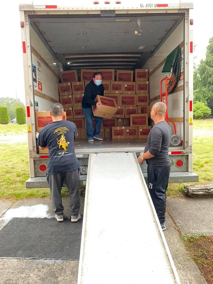 Two men are loading boxes into a truck.