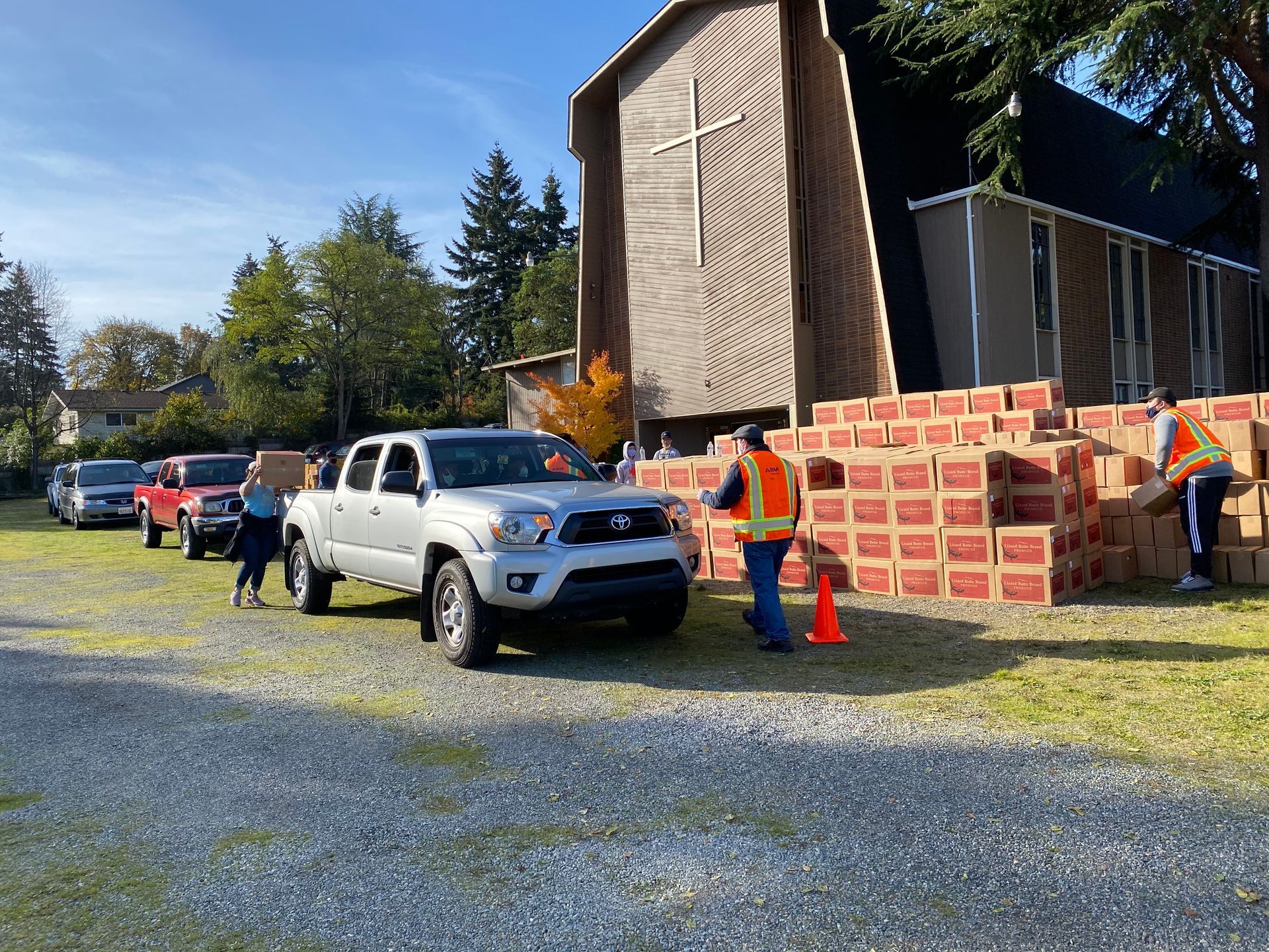 A row of trucks are parked in front of a church.