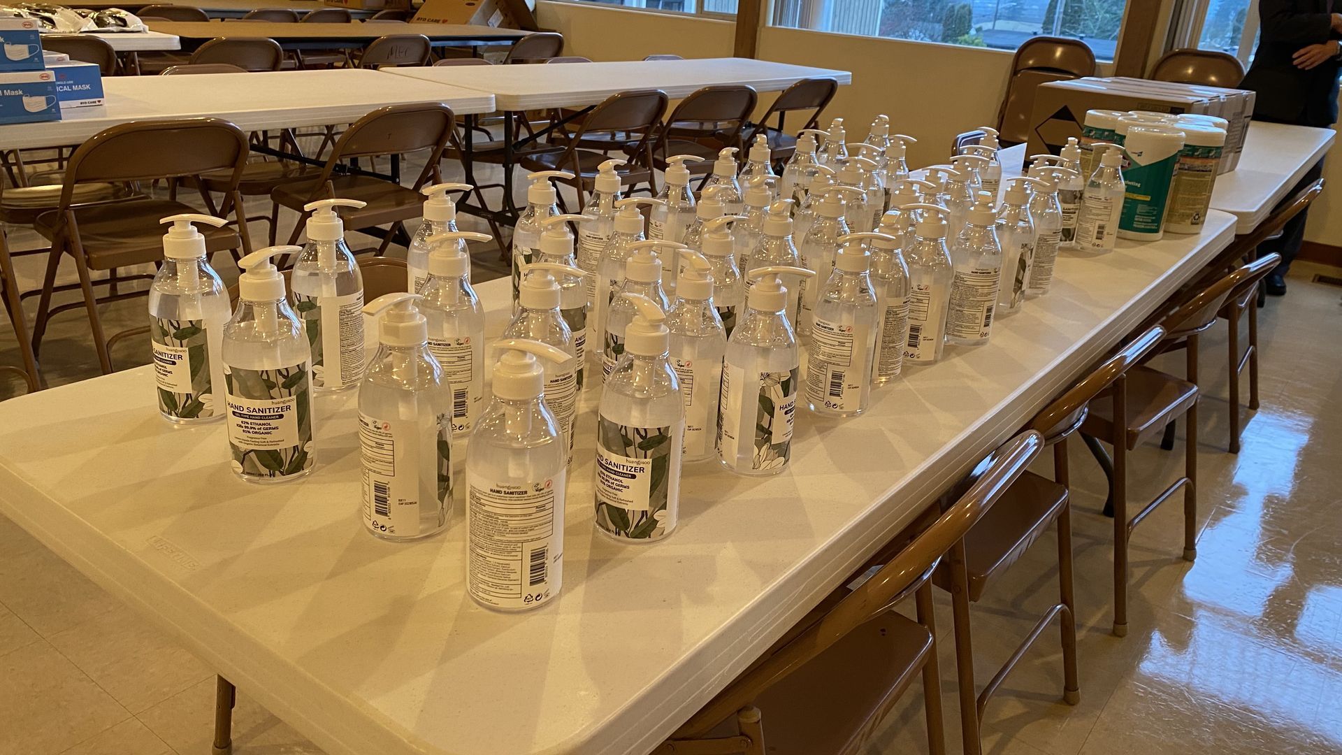 A table filled with lots of bottles of hand sanitizer.