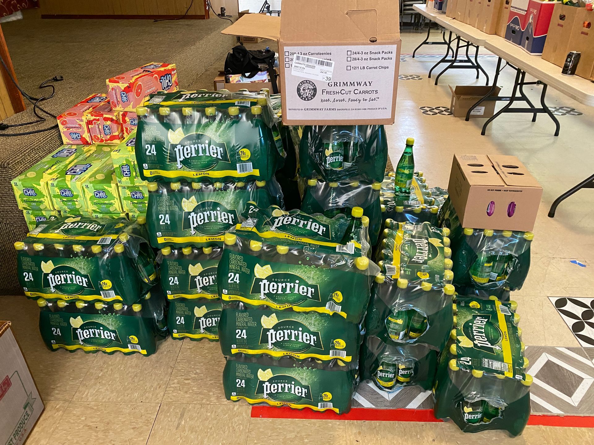 Boxes of perrier water are stacked on top of each other in a room.