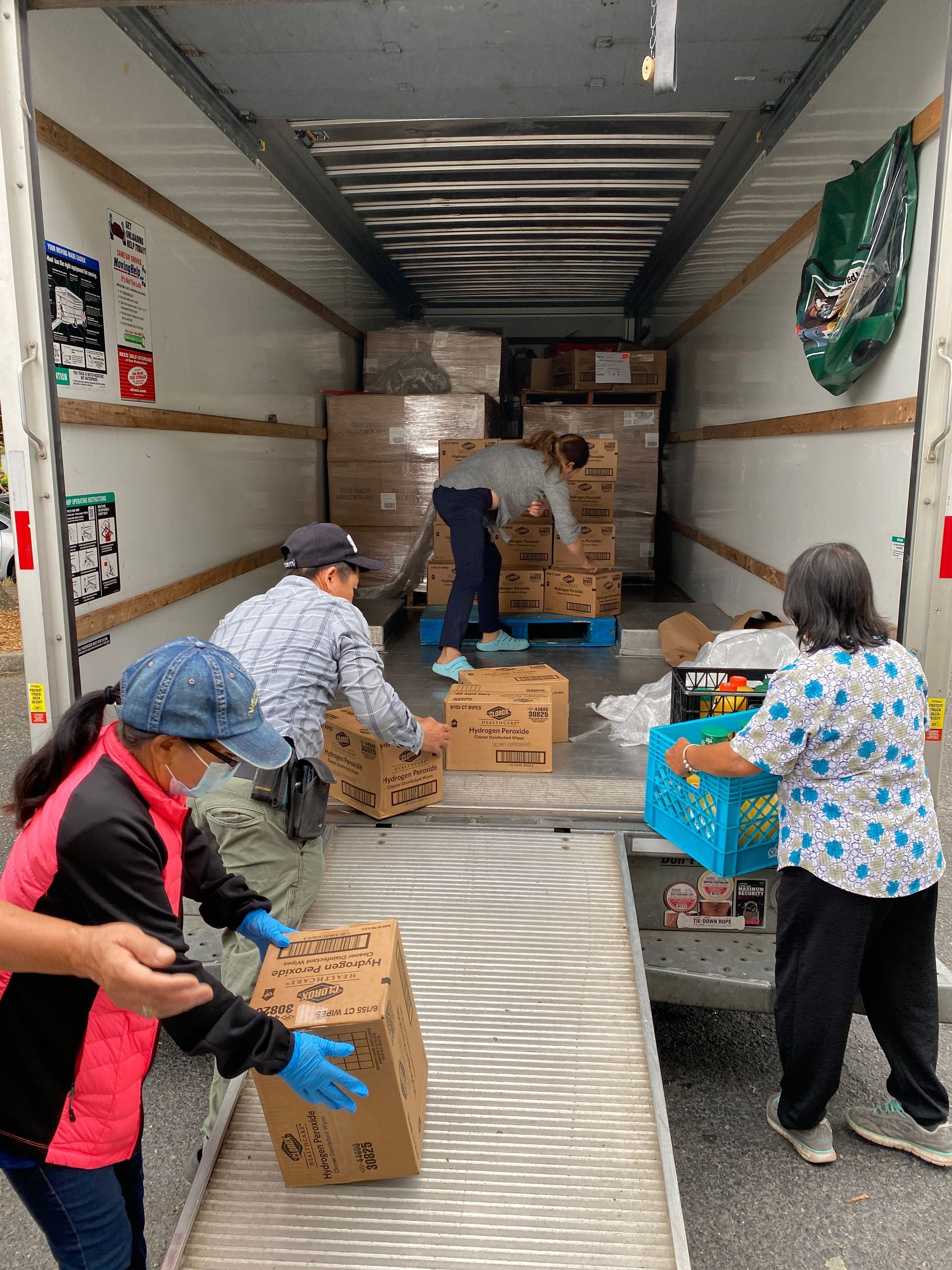 A group of people are loading boxes into a truck.